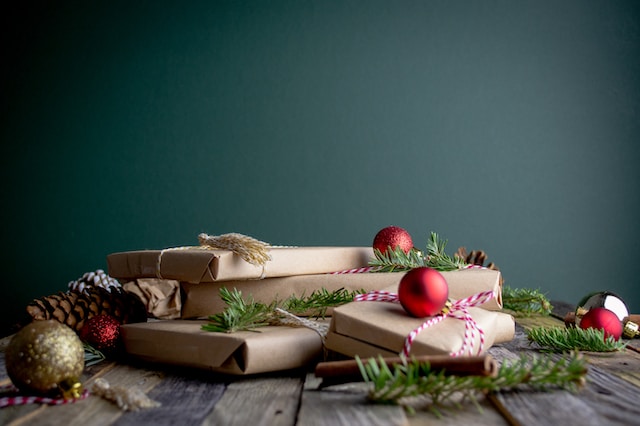 photo of a stack of presents with holiday decor around it