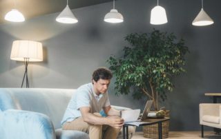 man sitting on couch working on computer