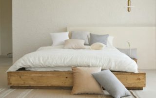 photo of a neat and tidy made bed with pillows on it