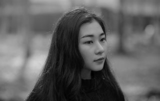 asian woman with serious look on her face looking at something off camera