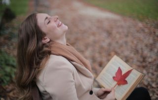 woman reading a book on a park bench