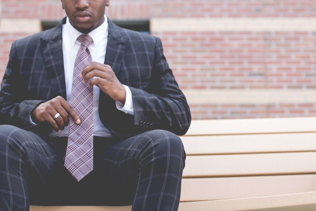 man sitting on stairs wearing business suit