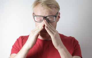 photo of a man holding his face in hands who looks distressed and anxious