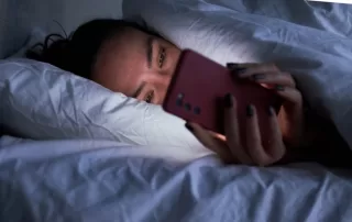 woman using phone in bed