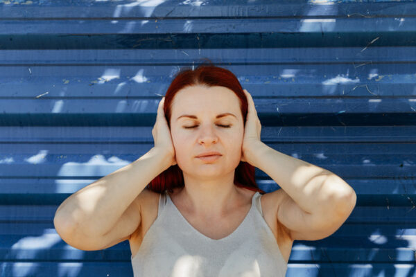 a woman with hand over her ears