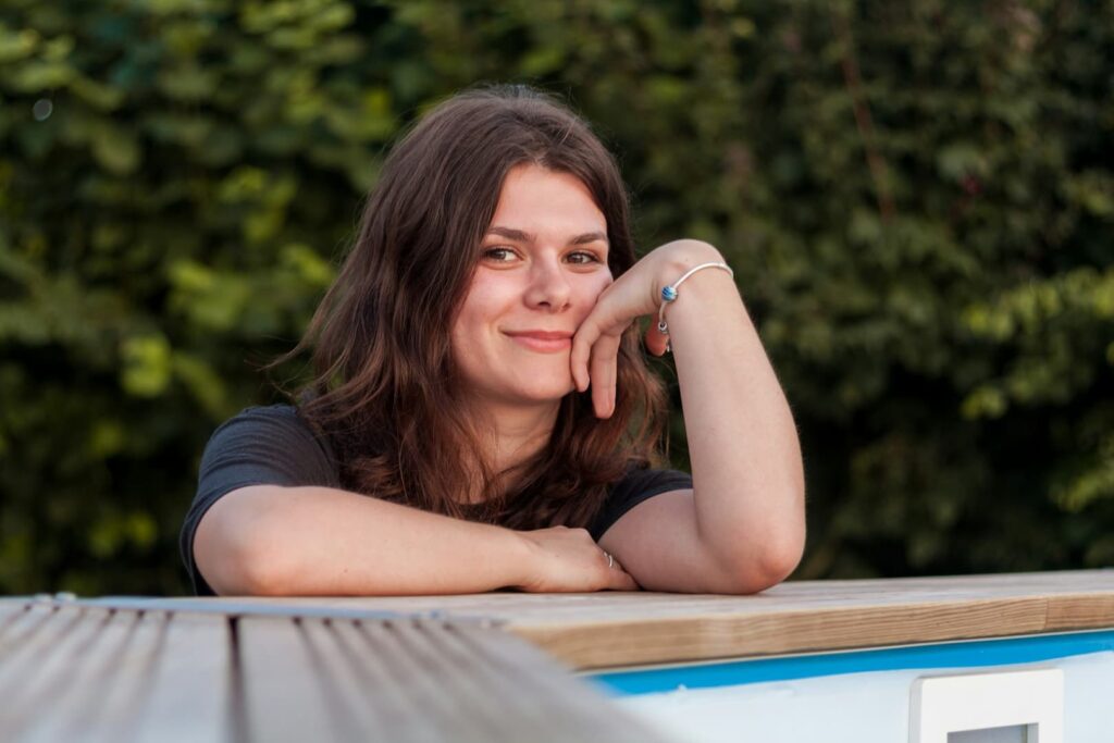 womans-face-on-her-arm-while-leaning-on-brown-surface