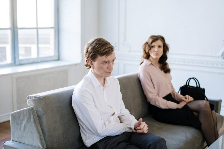 man-in-white-suit-sitting-beside-woman-in-black-dress