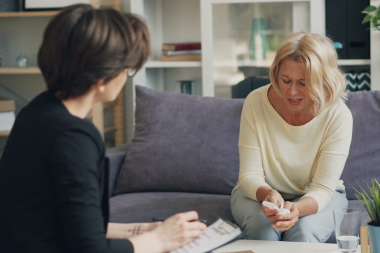 two-women-sitting-on-a-couch-talking-to-each-other