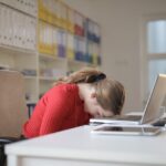 woman-sitting-on-chair-while-leaning-on-laptop