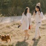 family-walking-on-grass-field-with-their-dog