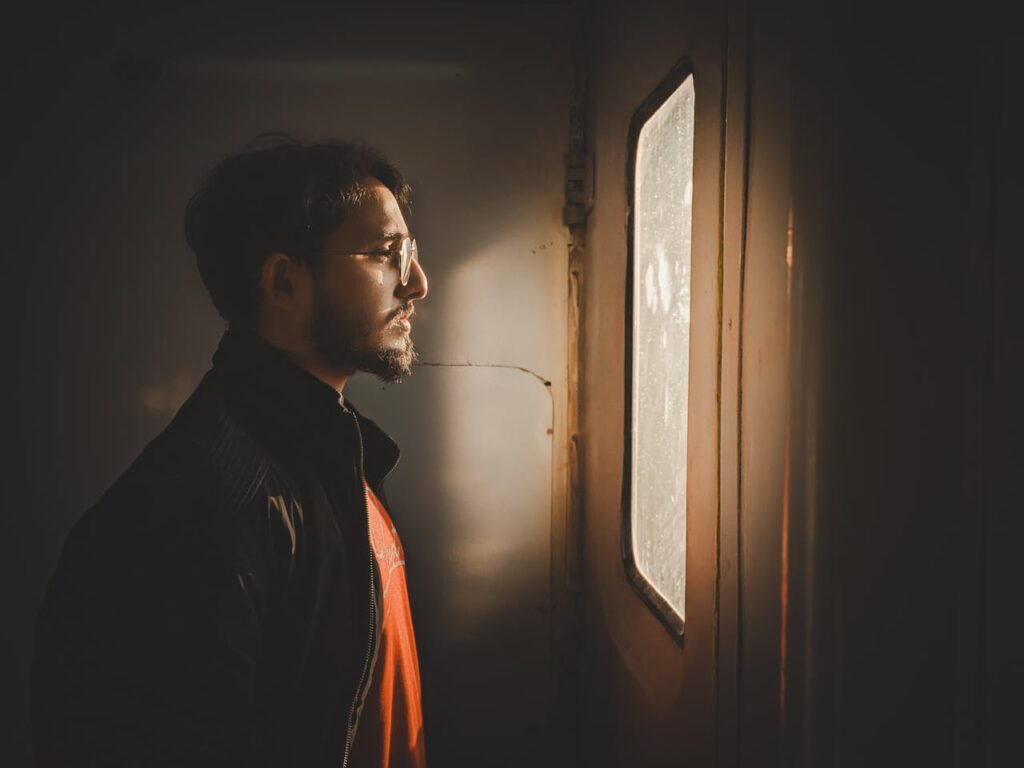 pensive-man-gazing-out-window-in-warm-light