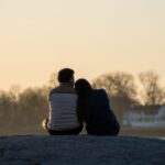 couple-enjoying-sunset-on-rocky-shore