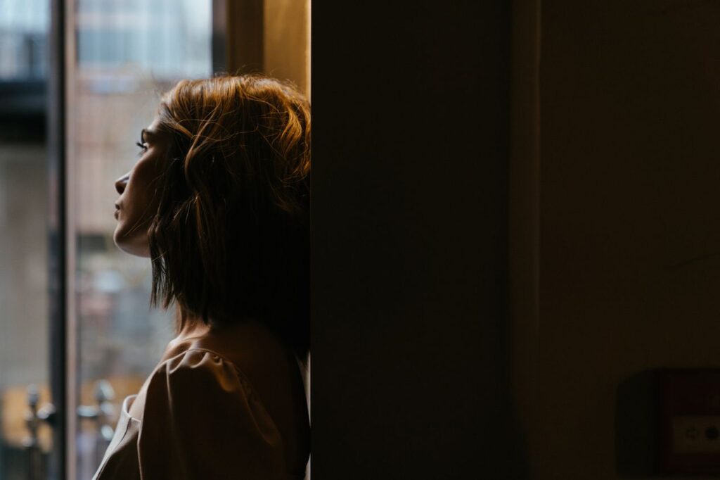 woman-in-white-shirt-looking-out-the-window